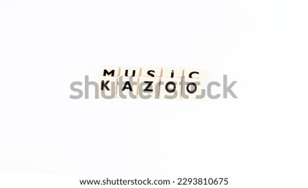 Letters that say Kazoo and music isolated on a white background. Music or kazoo background idea concept. Top view photo. Copy space. Blank, empty area. No people, nobody. wind instrument.