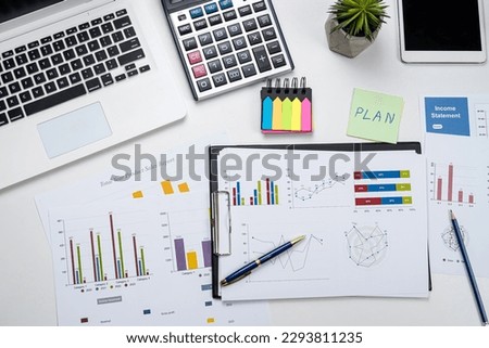 Business office desk with graph or annual report with laptop, pen calculator. Business financial and accounting concept.
