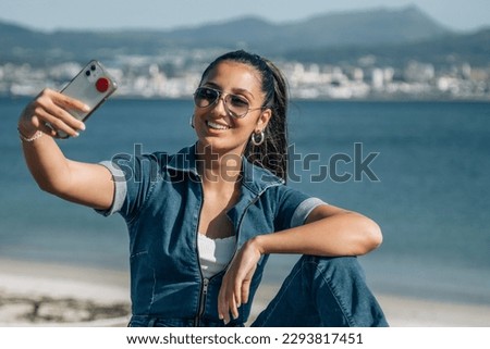 young latin hispanic woman with phone making a selfie seabed