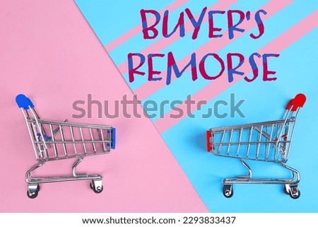 Text Buyer's Remorse and shopping carts on pink and light blue background, top view Royalty-Free Stock Photo #2293833437
