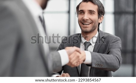 Portrait of cheerful young manager handshake with new employee.