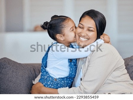 Adorable little girl kissing her mom on cheek while bonding at home. Loving, caring and affectionate mother and daughter spending quality time together. Woman being spoiled on mothers day