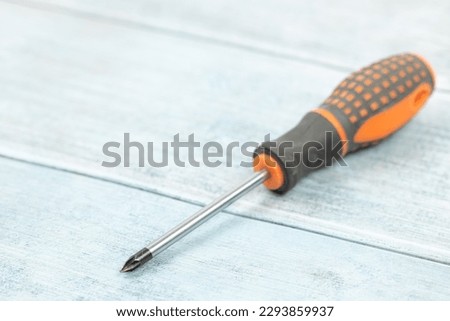 Screwdriver on the blue wooden planks background with copy space.