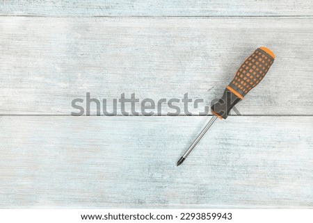 Screwdriver on the blue wooden planks background with copy space. Royalty-Free Stock Photo #2293859943