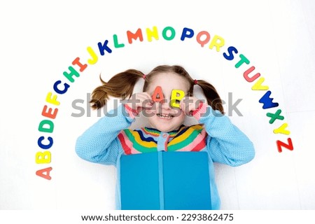 Happy preschool child learning to read and write playing with colorful roman alphabet letters. Educational abc toys and books for kids. School student doing homework. Kid reading in kindergarten. Royalty-Free Stock Photo #2293862475