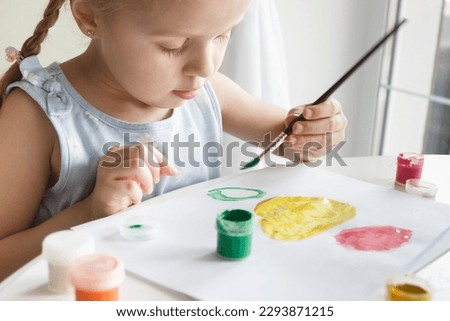 Little child draws with watercolor, concept of education in the kindergarten, soft focus background