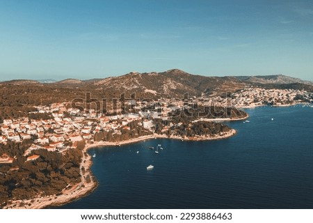 This stunning aerial photograph captures the beauty of Hvar's coastline, showcasing the sparkling turquoise waters, rugged cliffs, and pristine beaches. Perfect for designs featuring travel.
