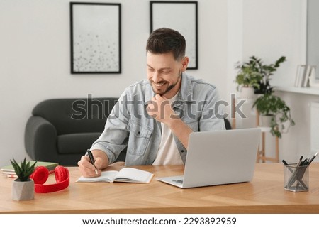 Online translation course. Man writing near laptop at home