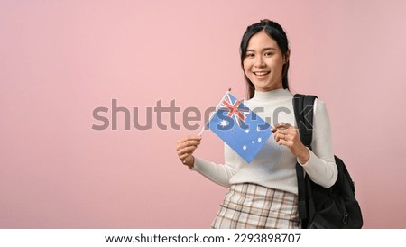 Beautiful girl showing a Australia flag on pink isolated background, education concept. study abroad concept. Royalty-Free Stock Photo #2293898707