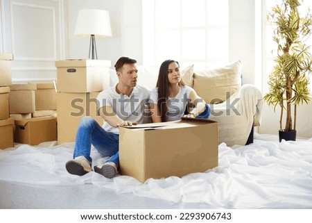 Happy young couple unpacking boxes in their new home.