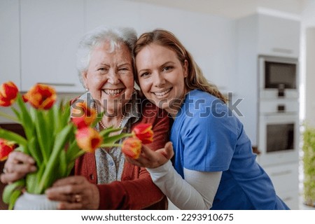 Senior woman and nurse with tulip bouquet. Royalty-Free Stock Photo #2293910675