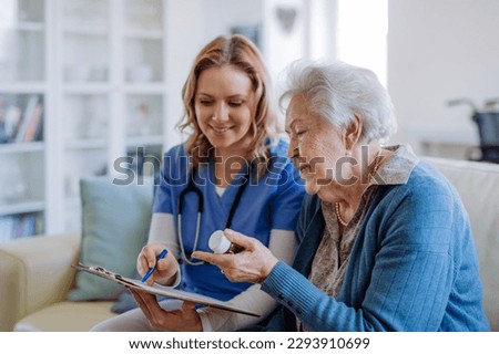 Nurse explaining how to dose medicines to senior woman.