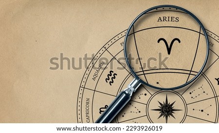 The imprint of the zodiac sign Aries on old paper is enlarged with a lens