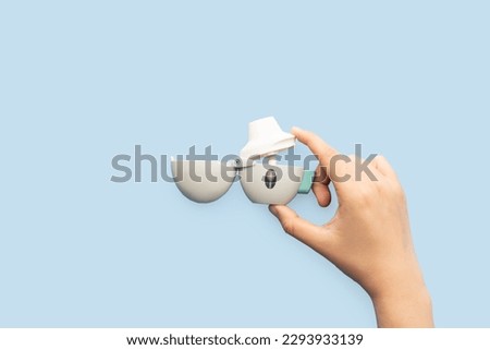 Prepare asthma inhaler for use. Woman hands put Tiotropium bromide capsule in chamber of inhaler and close mouthpiece. Pharmaceutical products is used to treatment COPD and asthma. Royalty-Free Stock Photo #2293933139