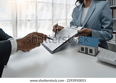 Real estate agent talked about the of the home purchase agreement and asked the customer to sign the documents to make the contract legally, Home sales and home insurance concept