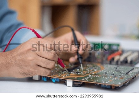 Technician using tool to measure circuit board, check and repair Royalty-Free Stock Photo #2293955981