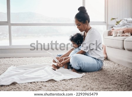 Time for cartoons. Full length shot of a young woman sitting in the living room with her daughter and using a digital tablet.