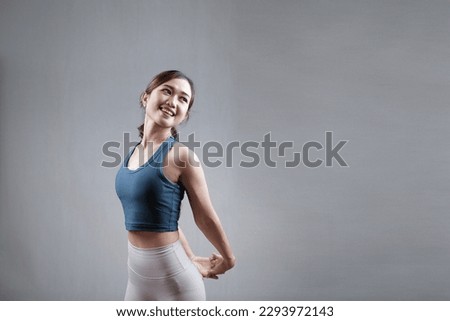 indonesian, asian young woman wearing sportswear stretching indoors before exercising