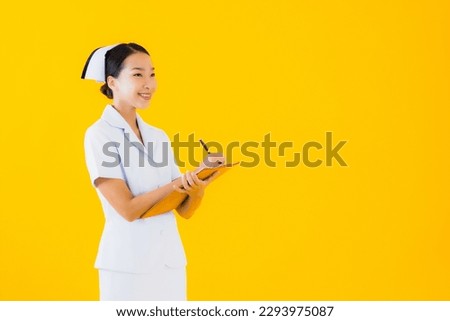 Portrait beautiful young asian woman thai nurse show empty white board and work at clinic or hospital on yellow isolated background