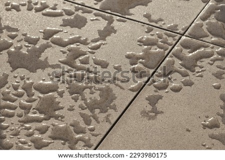 Water on ceramic balcony tiles after their impregnation with anti-absorption agent. Photo taken after morning rain. Royalty-Free Stock Photo #2293980175
