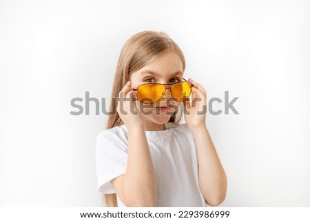 Beautiful young girl in fashionable glasses on a white background shows emotions