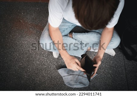 A desperate Asian opening wallet and looks at his empty wallet. Unhappy Asian people with no cash in their purses, bankrupt economic financial , Poverty in retirement, and unemployment concept. Royalty-Free Stock Photo #2294011741