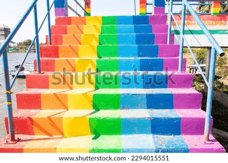 Way up from canal by stairs colorful rainbow or freshwater lake in one of tourist attractions in Thailand. Rainbow is symbol LGBTQ is term used to refer to people of different gender is diverse group.