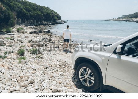 car travel concept man at summer beach looking at sea