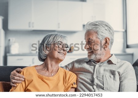 Happy mature husband and wife sit rest on couch at home hugging and cuddling, show care affection, smiling senior loving couple relax on sofa have fun, enjoy tender romantic family weekend together Royalty-Free Stock Photo #2294017453
