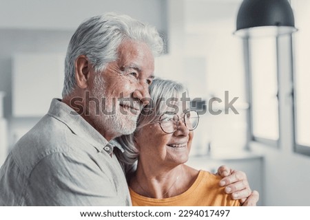 Dreamy middle aged senior loving retired family couple looking in distance, planning common future or recollecting memories, enjoying peaceful moment relaxing together on cozy sofa in living room Royalty-Free Stock Photo #2294017497