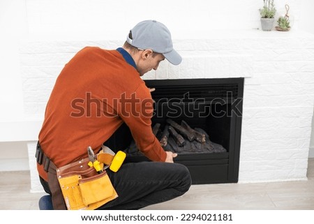 Man cleaning fireplace from ashes.