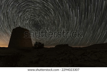 A mesmerizing photo of a starry sky, with the Star Trail shining brightly above an ancient tomb in the background.
