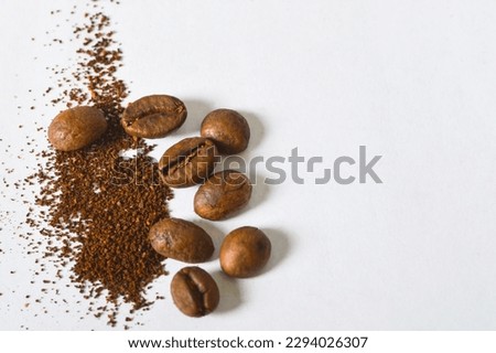 Roasted coffee beans and ground coffee on the light background