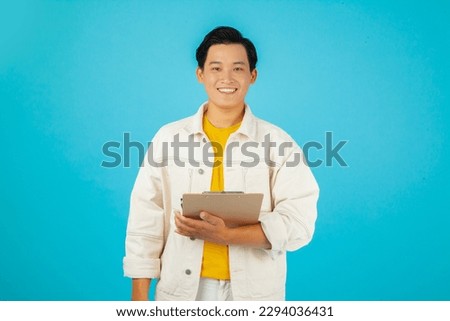 Handsome healthy young Asian man smiling with his finger pointing isolated on light blue banner background with copy space 