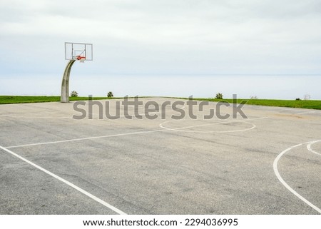 Empty basketball court overlooking the ocean on a cloudy and foggy autumn morning