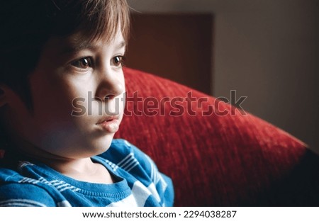 Beautiful brown eyes of 6 year boy looking at screen close-up. Child is watching TV, cartoons or video too long. Side view. The concentrating kid. Plays computer game. Vision load. Attention.