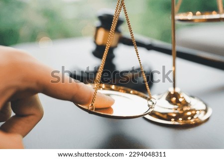 Tip the scales of justice concept as a the hand of a person illegally influencing the legal system for an unfair advantage.	
 Royalty-Free Stock Photo #2294048311