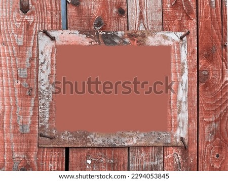 А rough frame on an old red fence, nailed down