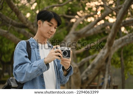 Portrait of Tourist young man using film camera taking a picture.