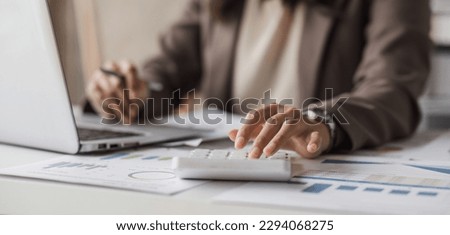 Close-up of businesswoman hands using a calculator to check company finances and earnings and budget. Business woman calculating monthly expenses, managing budget, papers, loan documents, invoices. Royalty-Free Stock Photo #2294068275