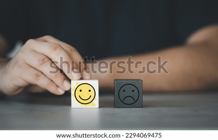 Concept of emotional management. Man chooses a wooden cube with a happy face in thought. Mental health day. Compliment day. Dealing with emotional angry, stress management concept Royalty-Free Stock Photo #2294069475
