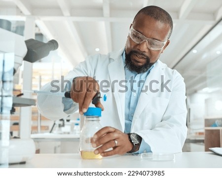 Lets see whats causing the infection. Shot of a handsome mature scientist sitting alone in his laboratory and opening a bottle of liquid for testing.