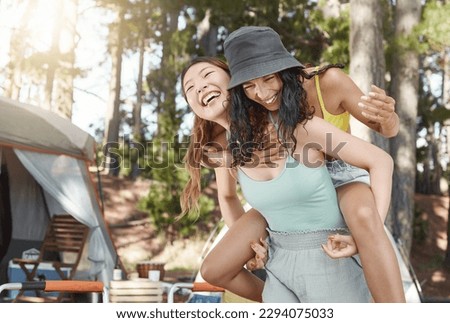Staying young at heart. Shot of an attractive young woman giving her friend a piggyback ride during a day in the woods. Royalty-Free Stock Photo #2294075033
