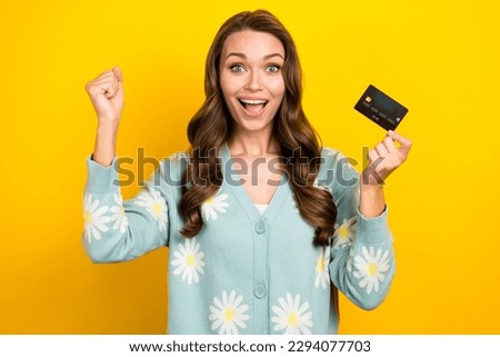 Photo of young successful businesswoman glamour stylish cardigan flowers ornament fist up jackpot win hold card isolated on yellow color background