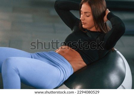 Showing abs. Beautiful woman with sport body type is in the gym.