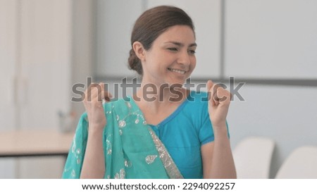 Portrait of Indian Woman in Sari Dancing and Enjoying Music