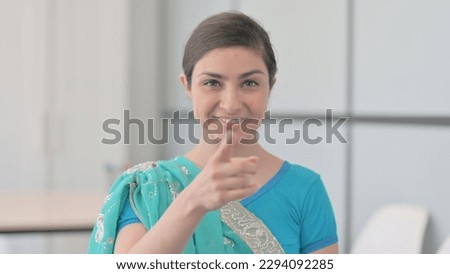 Portrait of Indian Woman in Sari Pointing at Camera