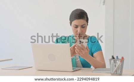 Indian Woman in Sari Using Phone at Work