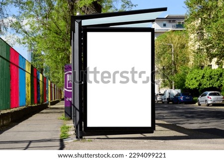 blank lightbox and glass bus shelter at busstop. urban street background. white ad poster. display panel. empty outdoor ad space. mockup base.  cars on the road. street setting. blurred surrounding.