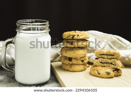 Freshly baked cookies with chocolate on a baking sheet. Chocolate chip cookies are stacked. Space for text